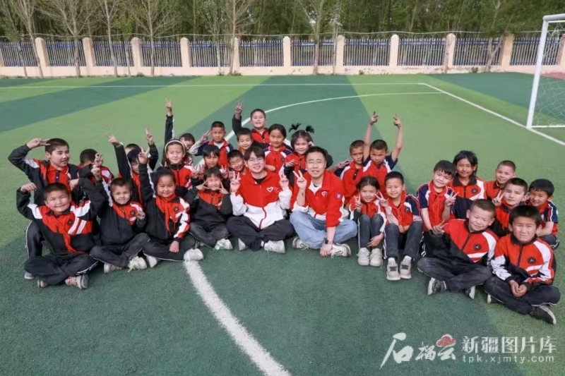 4月30日，志愿者李轲凡（前中右）、王俊文（前中左）与学生们在一起。谢依特小学供图