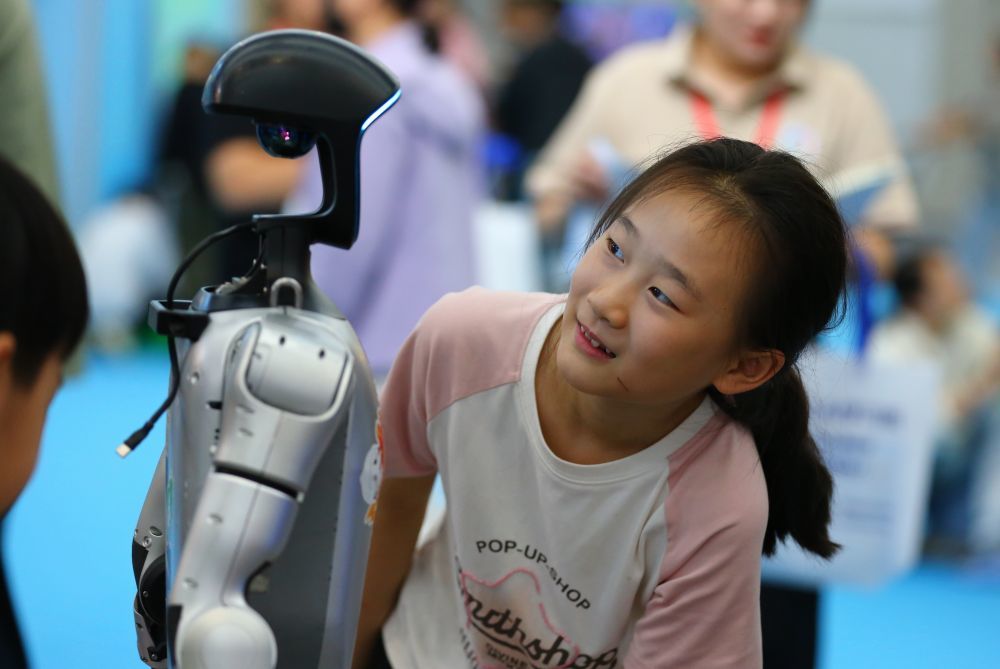10月2日,在山东省第九届滕州书展现场,小朋友与机器人互动。新华社发(李志军摄)