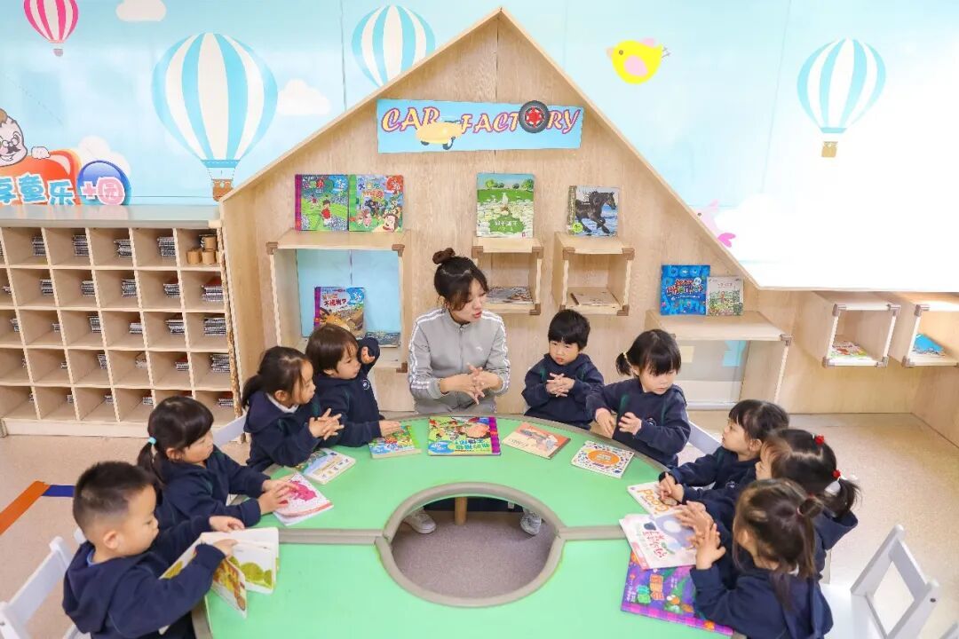 2025年11月4日,在山东青岛恒星科技学院恒星托育中心,老师带领小朋友阅读绘本故事。中新社发 张鹰 摄