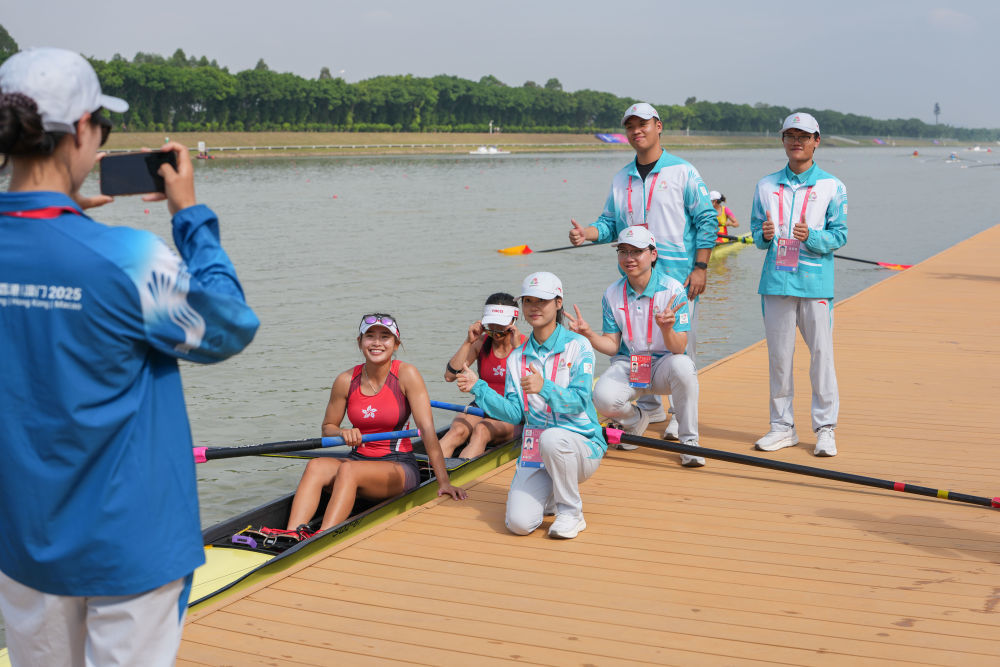 11月8日,香港队赛艇选手黄湘仪/梁琼允在女子双人单桨半决赛后与志愿者合影留念。新华社记者 肖恩楠 摄