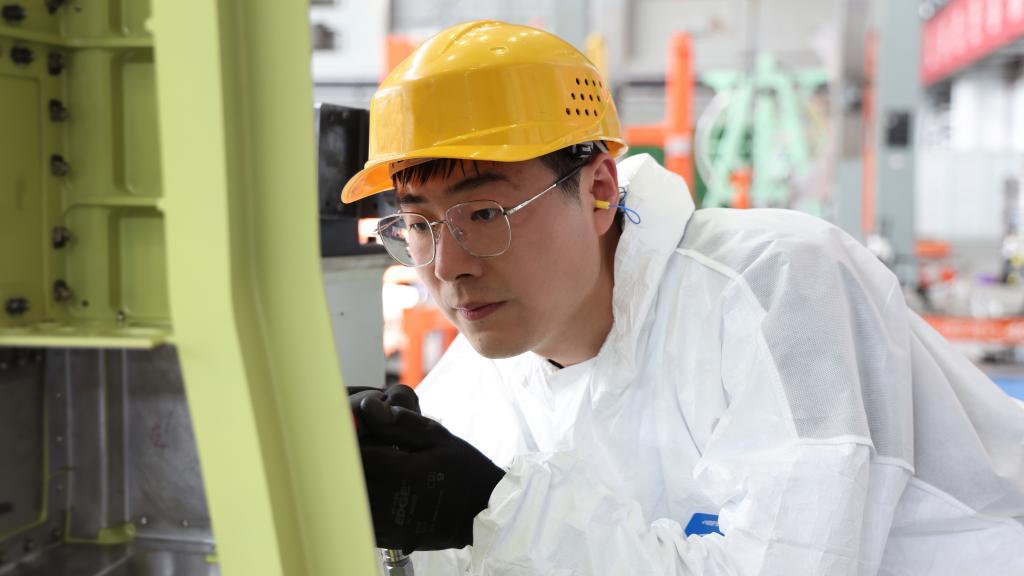 在中国航空工业集团成飞车间内，飞机铆装钳工首席操作技师冯攀龙正在工作。（新华社发）