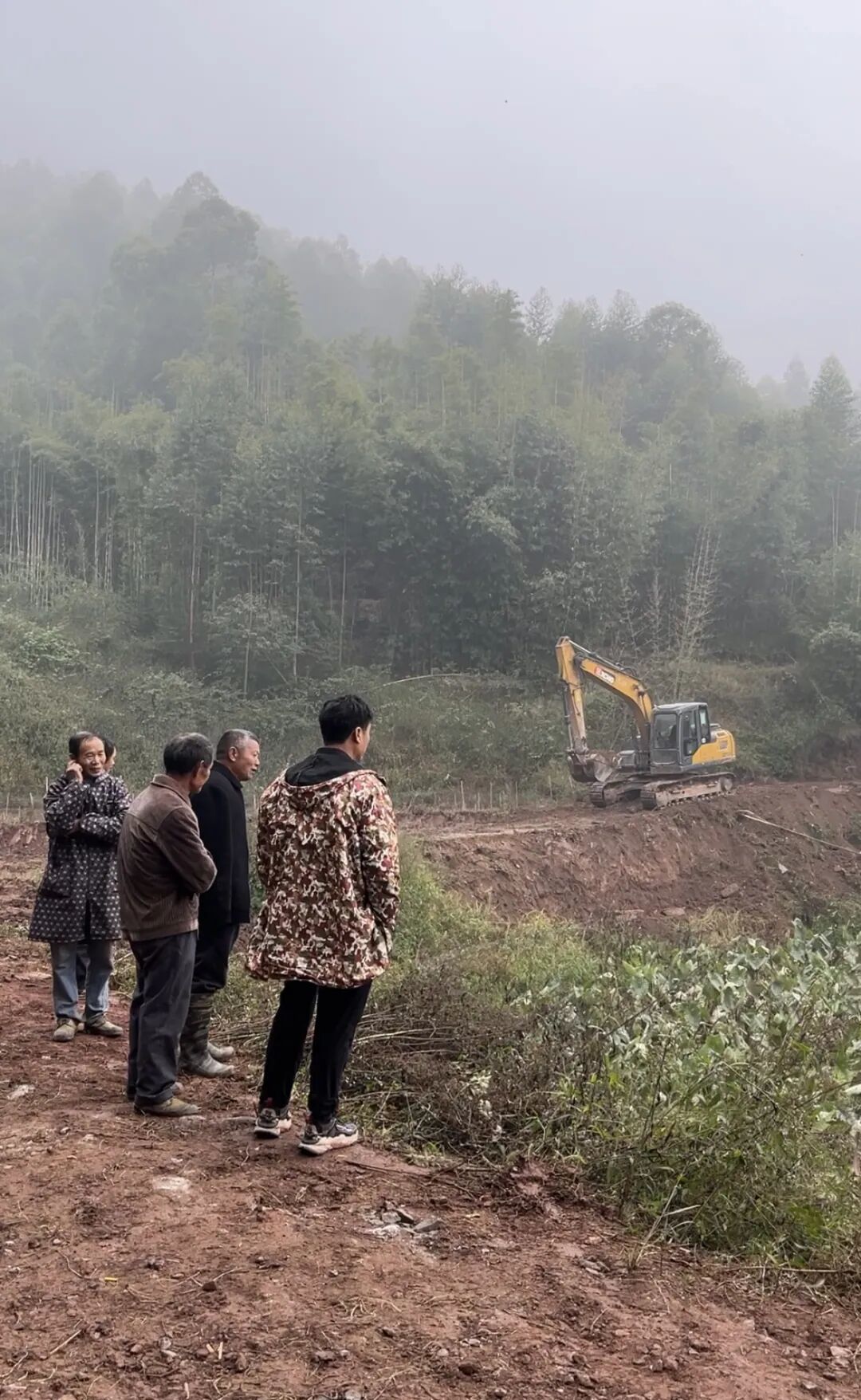 12月11日,青龙村10组村民围观修路。