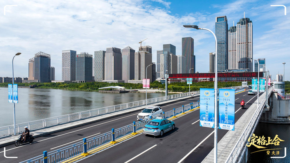 在天津市滨海新区，道路旁的路灯上悬挂着“2025上海合作组织峰会”等标识。