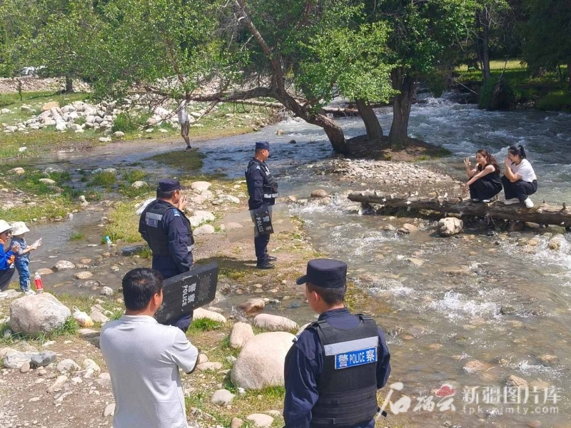 叶尔兰·吐勒甫别尔干与同事在景区对游客开展防溺水安全宣传教育。图片由尼勒克县公安局提供。