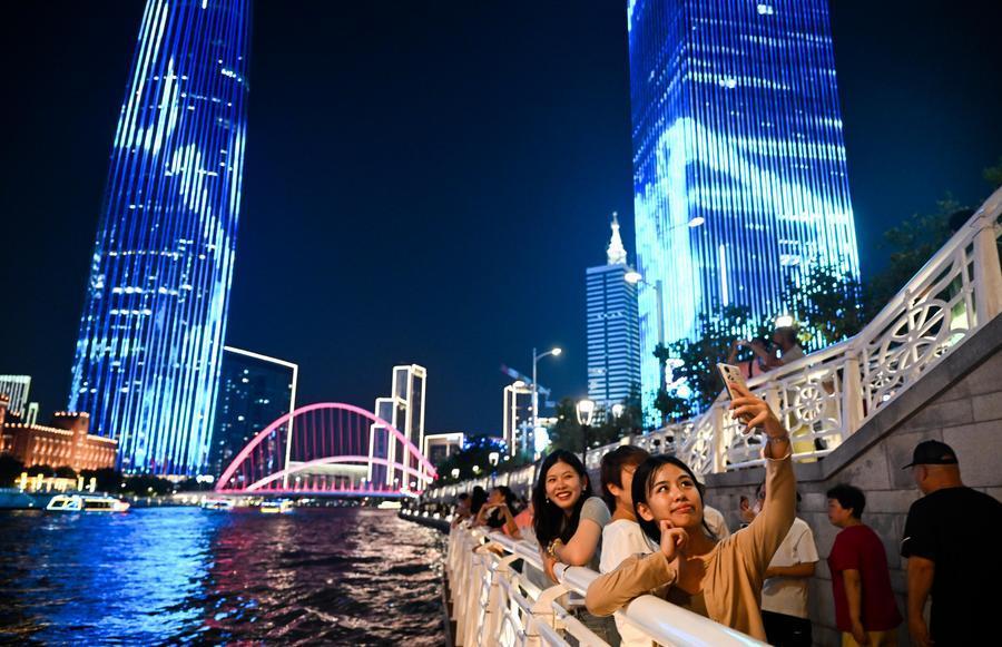 2025年8月11日,游客在天津海河岸边拍照打卡。新华社记者 赵子硕 摄
