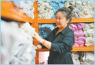 阿拉坦其其格在羊绒店内整理货品。　