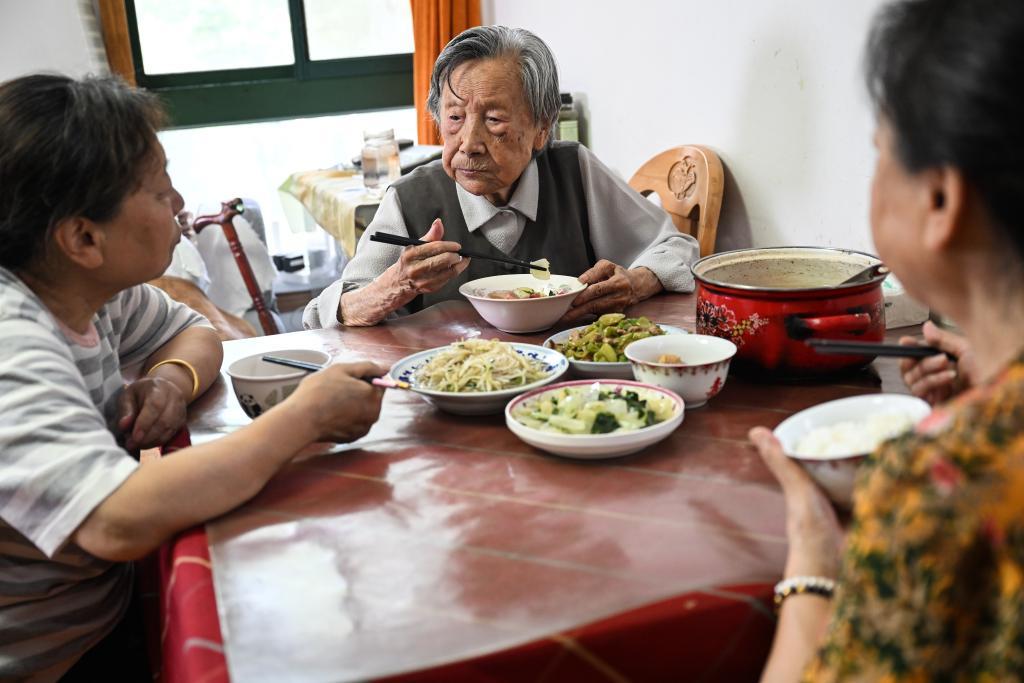 ↑2025年5月21日，夏淑琴（中）和两个女儿在南京家中吃午饭。