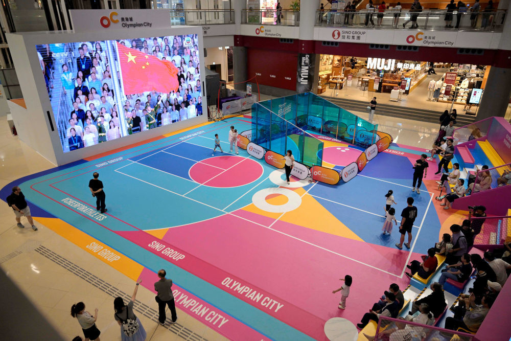 11月9日,第十五届全国运动会开幕式在广东奥林匹克体育中心举行,这是香港市民在一家商场内观看直播。新华社发(卢炳辉 摄)