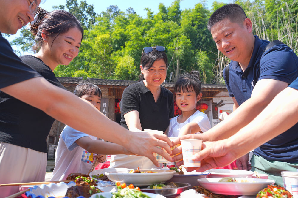 10月6日,在重庆市北碚区金刀峡镇胜天湖村“九斗碗坝坝席”现场,游客举杯共庆中秋佳节。新华社发(秦廷富摄)