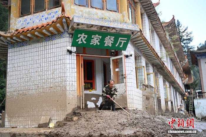 8月11日，与兴隆山标志性建筑卧桥“守望”30多载的“农家餐厅”老板高伟元正在清理室内淤泥。九美旦增 摄