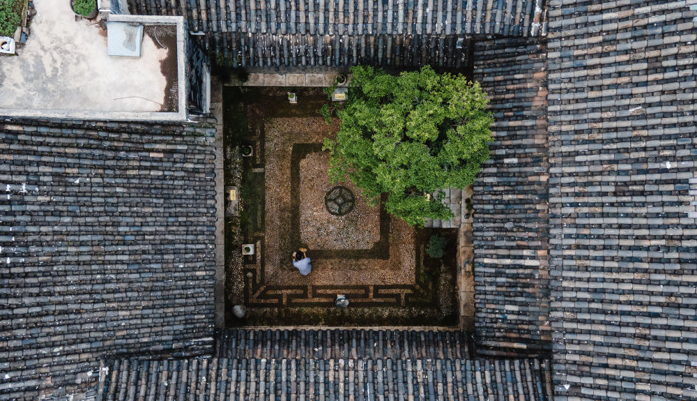 恒裕公民居博物馆主理人阿六叔在清理庭院（2022年6月10日摄，无人机照片）。新华社记者 王冠森 摄