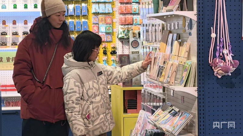 游客在观看云冈石窟的文创产品(央广网记者 张晋鹏 摄)