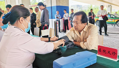 出租车司机在“的士之家”义诊摊位测量血压。　　本报记者  王昊男摄