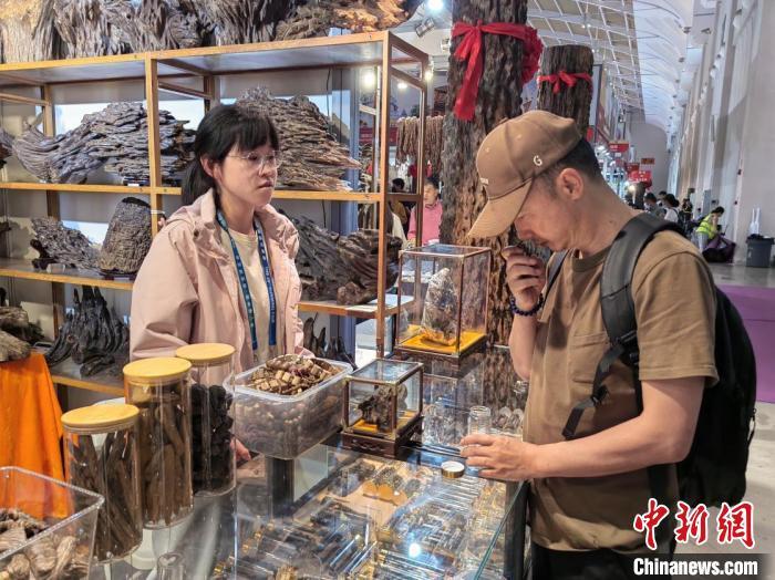 图为中国消费者在南博会上挑选越南沉香手串。王胜嫔 摄