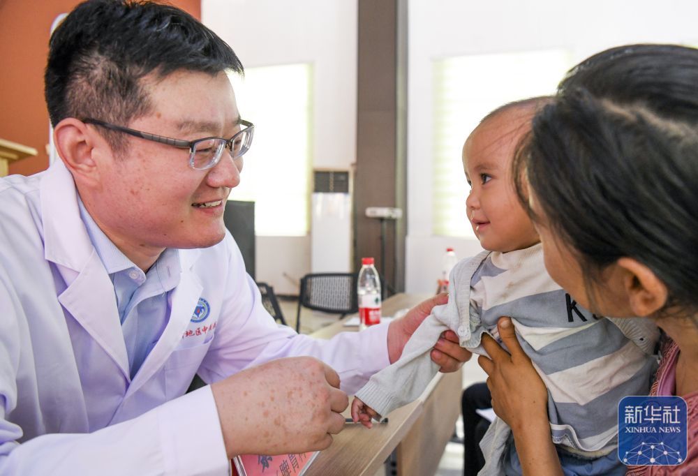 ↑ 在新疆喀什市夏马勒巴格镇团结小区，来自青岛大学附属医院的援疆医生綦鹏（左）为居民义诊（2023年9月16日摄）。新华社记者 王菲 摄