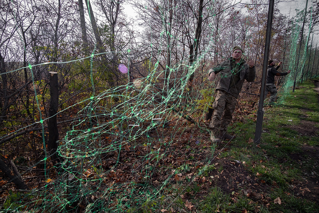 11月4日,顿涅茨克地区,乌克兰士兵在道路沿线安装反无人机网。(视觉中国)