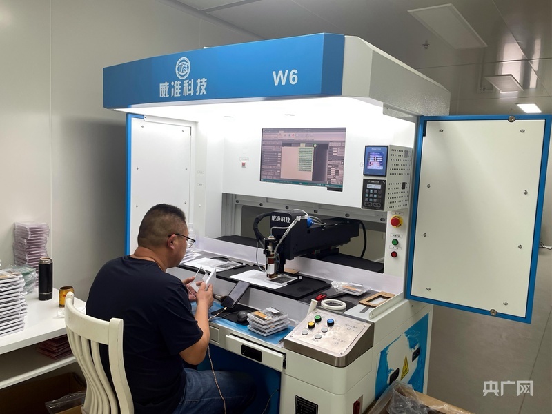 企业车间内的自动点胶机（央广网记者 唐磊 摄）