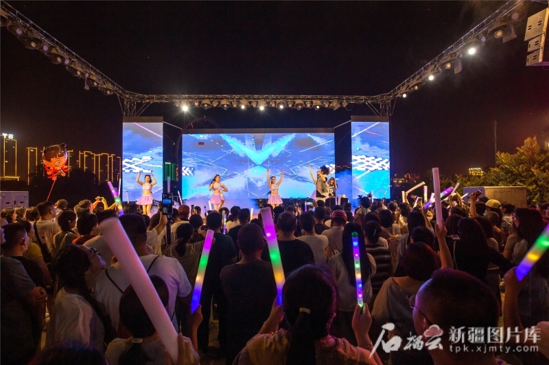 5月31日，游客在库车市城南街道南湖夜市音乐节观看演出。袁欢欢摄