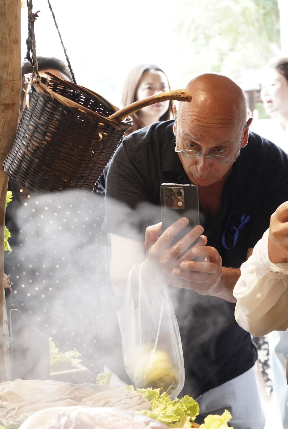 外国游客在四川旅游途中拍摄美食（2024年6月7日摄）。新华社记者 张超群 摄