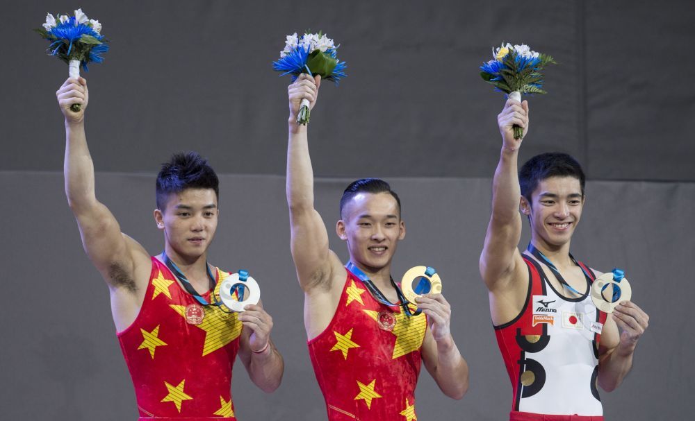 2017年10月5日,冠军肖若腾(中)、亚军林超攀(左)和季军日本选手白井健三在世界体操锦标赛男子全能颁奖仪式上。新华社发