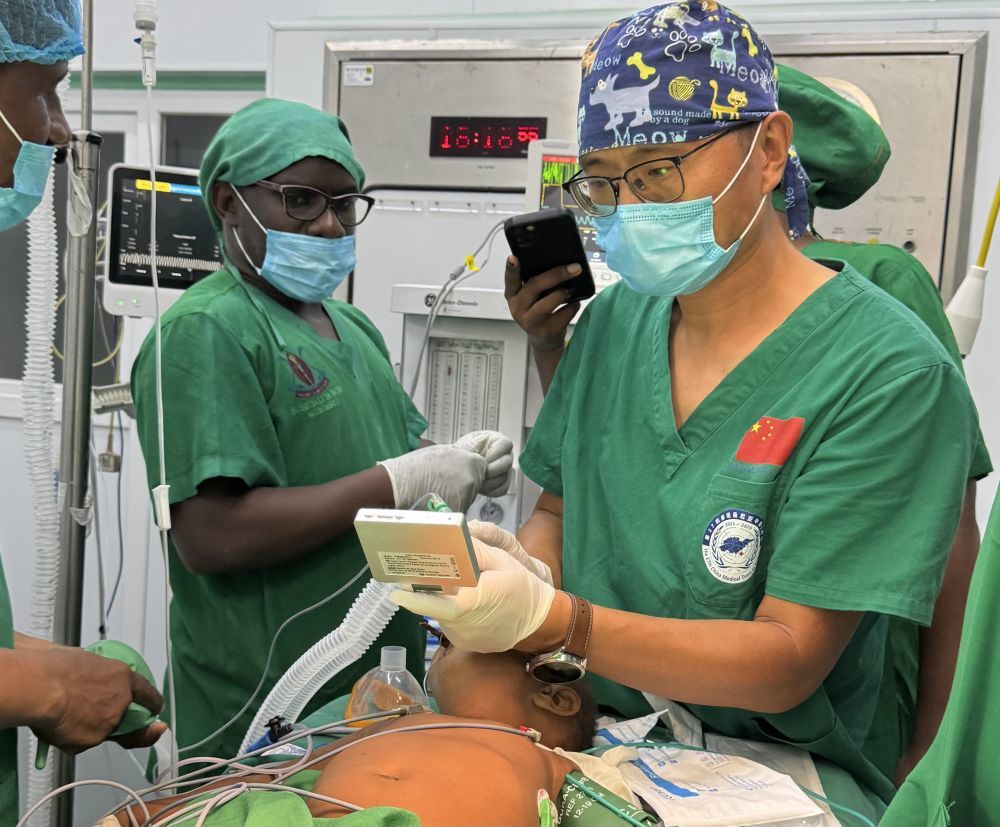 2025年3月21日，张军桥医生（右）在坦桑尼亚达累斯萨拉姆穆欣比利国立医院的手术台上工作。新华社发