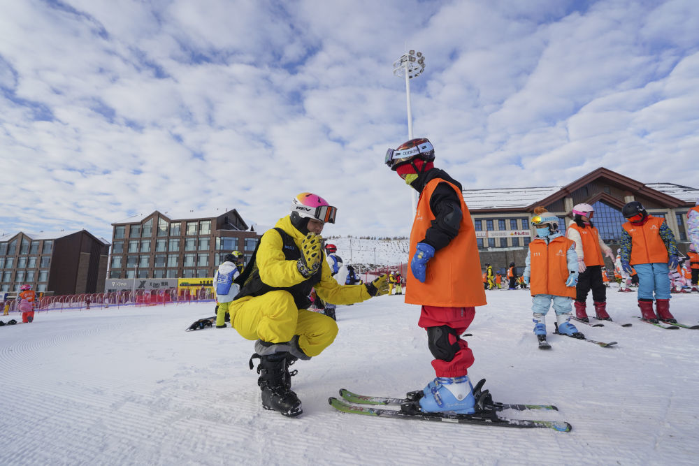 ↑滑雪教练在给学生讲解双板滑行技巧。新华社记者 阿曼 摄