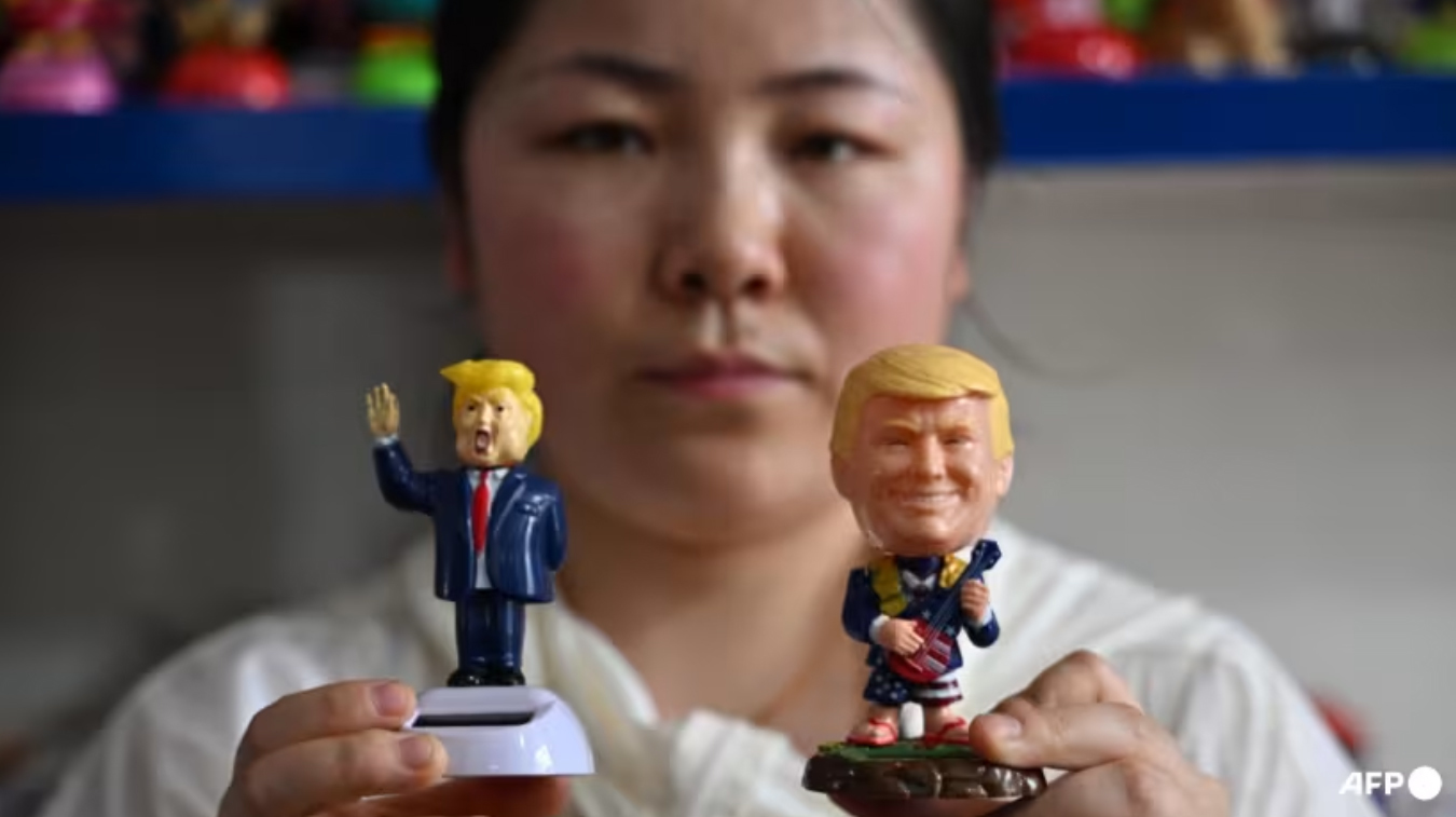 4月11日，浙江义乌，在一家专门生产太阳能塑料制品的工厂里，销售员卡西拿着美国总统特朗普肖像的人偶。 法新社
