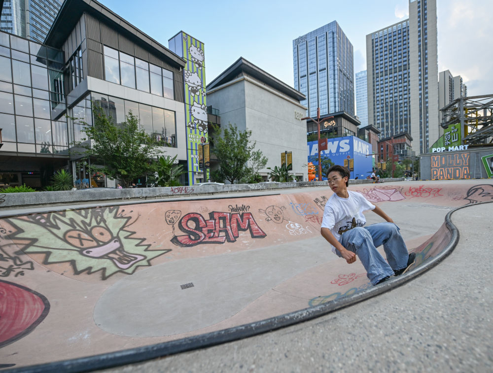 ↑8月6日,爱好者在成都东郊记忆户外滑板场练习滑板。新华社记者 王曦 摄