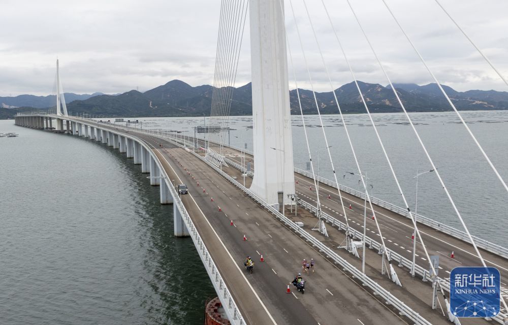 ↑ 在2025深港马拉松赛暨第十五届全国运动会田径（马拉松）测试赛中，运动员经过深圳湾大桥（2025年2月23日摄，无人机照片）。新华社记者 毛思倩 摄