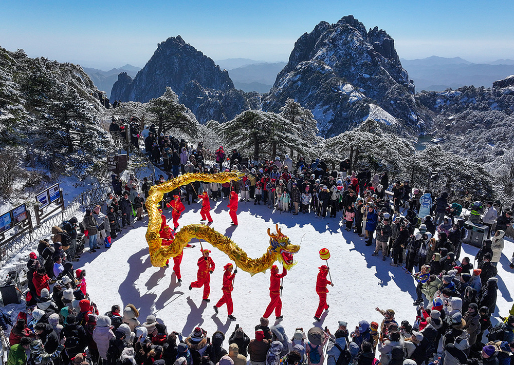 2025年1月27日，安徽黄山，舞龙队伍在雪后的黄山风景区光明顶处表演。视觉中国 图