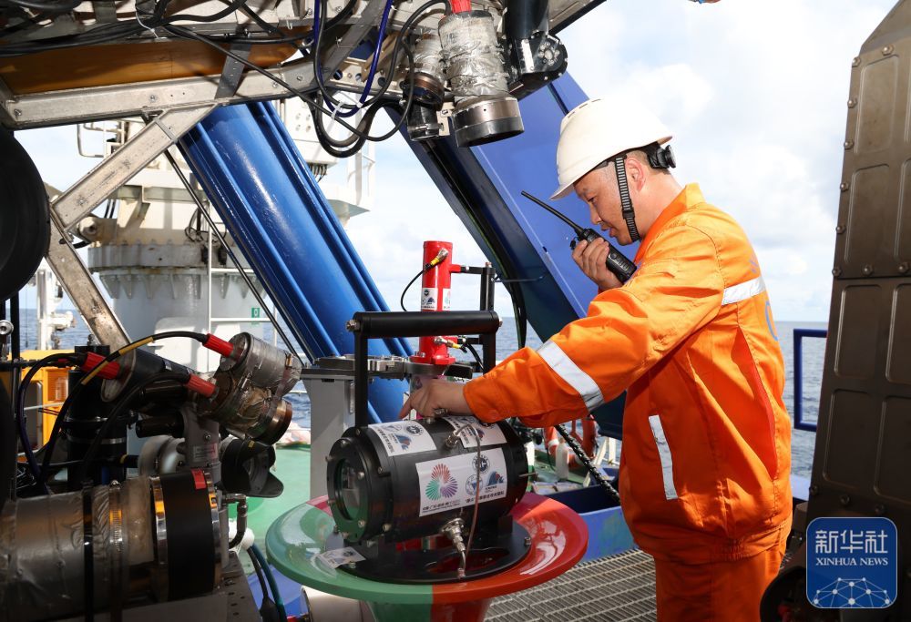 ↑9月18日，下水采集“源火”前，工作人员在调整搭载在“海马”号深海遥控潜水器上的采火装置。新华社记者 卢汉欣 摄