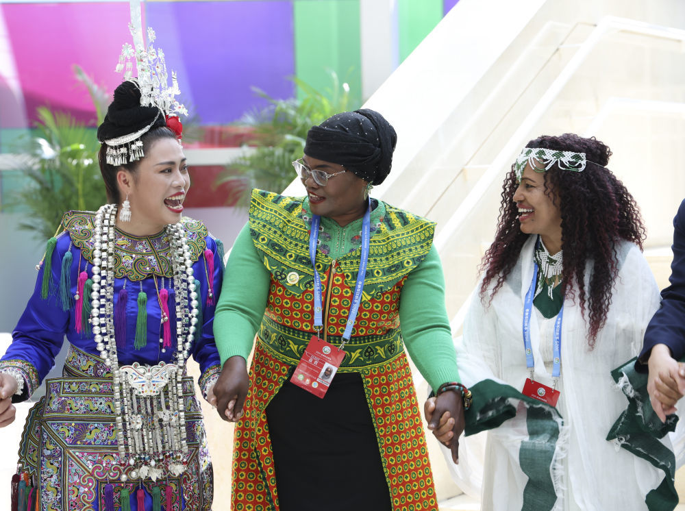 2025年10月14日，在全球妇女峰会配套活动“数智赋能妇女和女童成果展”，来自坦桑尼亚和埃塞俄比亚的嘉宾与侗族大歌表演者们一起载歌载舞。新华社记者 梁旭 摄