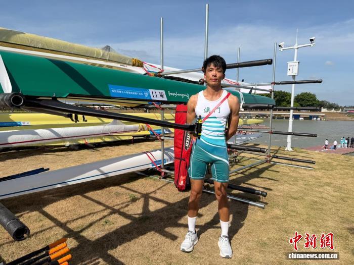 11月10日，第十五屆全國運動會賽艇項目男子羽量級單人雙槳決賽後，澳門隊選手朱銘琨與他的賽艇合影。王堅 攝