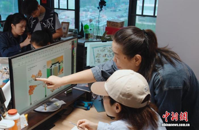 2025年9月22日，戴翎怡(前排右)与团队讨论文创产品设计。　王鑫 摄