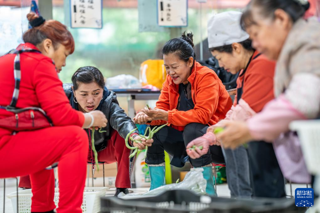 王兰兰(中)和义工们在昆明市幸福家园小区爱心食堂择菜(5月28日摄)。
