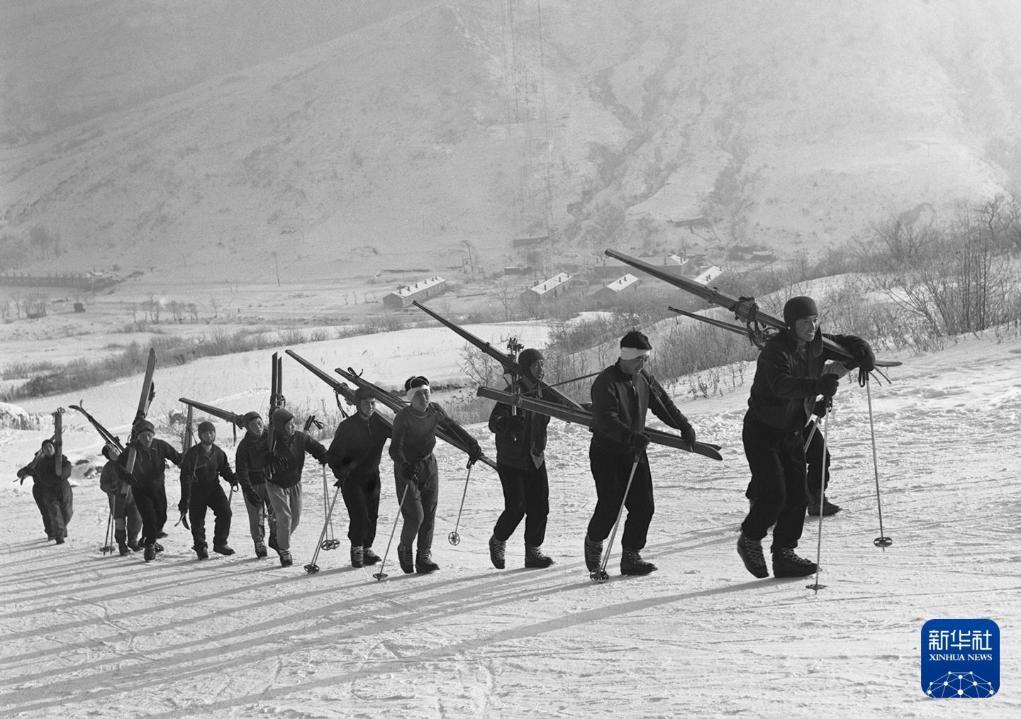 1965年1月24日到28日，全国滑雪锦标赛在吉林省通化市举行。在比赛前，滑雪运动员来到通化市金厂滑雪场，扛着雪板上山进行练习。新华社记者王敬德摄