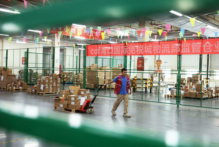 在海口综保区中免海南国际物流中心,工作人员搬运免税品(2025年5月26日摄)。新华社记者 金皓原 摄
