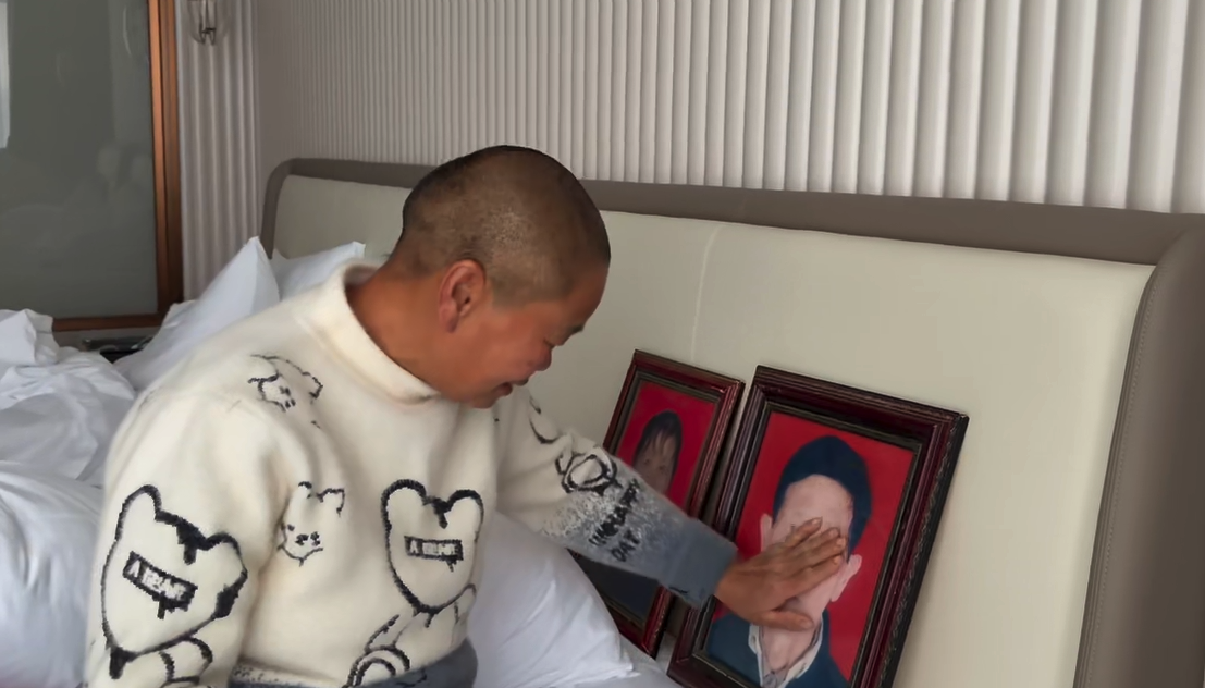 ▲李海玉抚摸父亲遗像