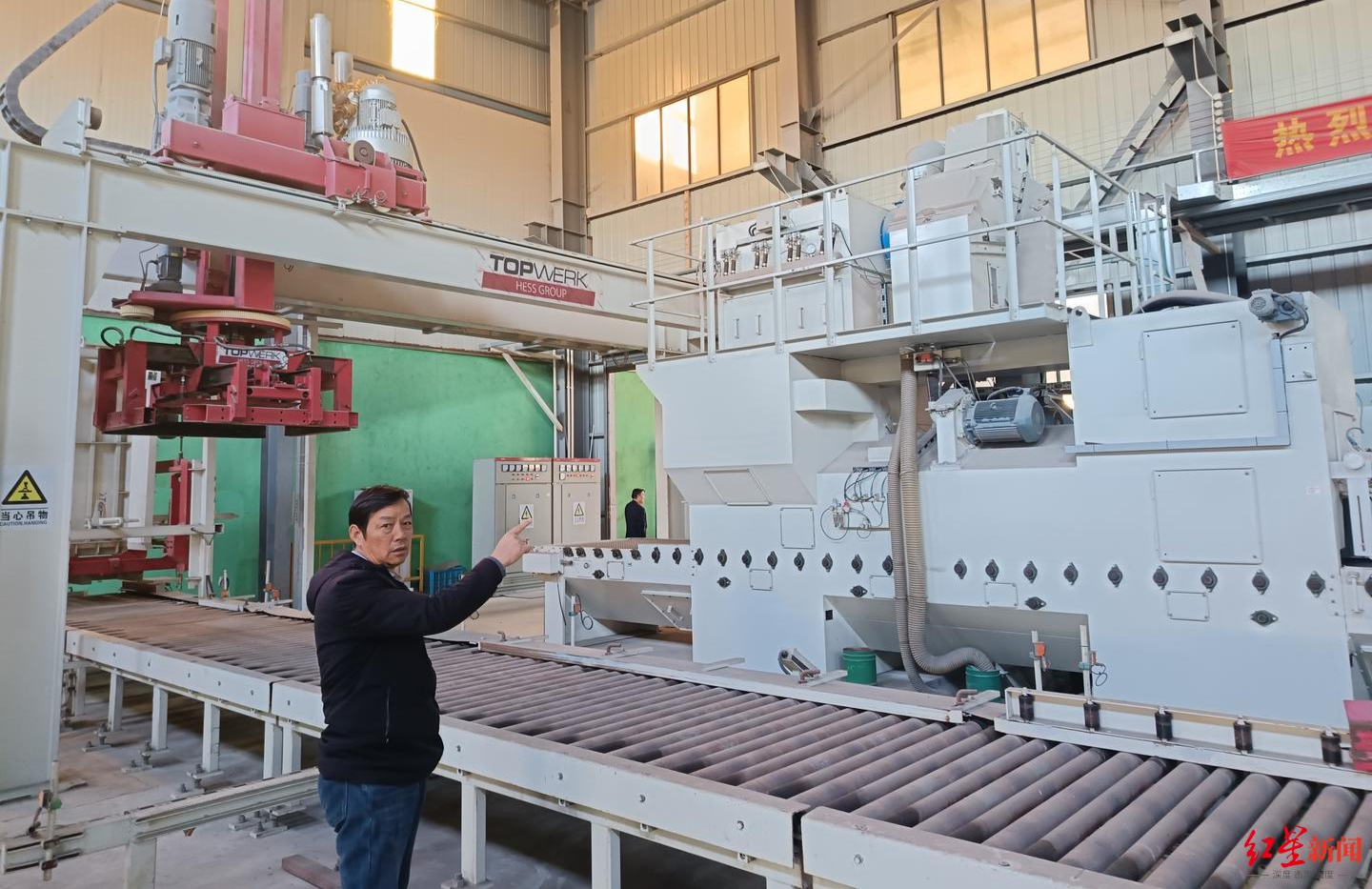 ▲王志立站在公司自动化生产线前,该生产线目前闲置