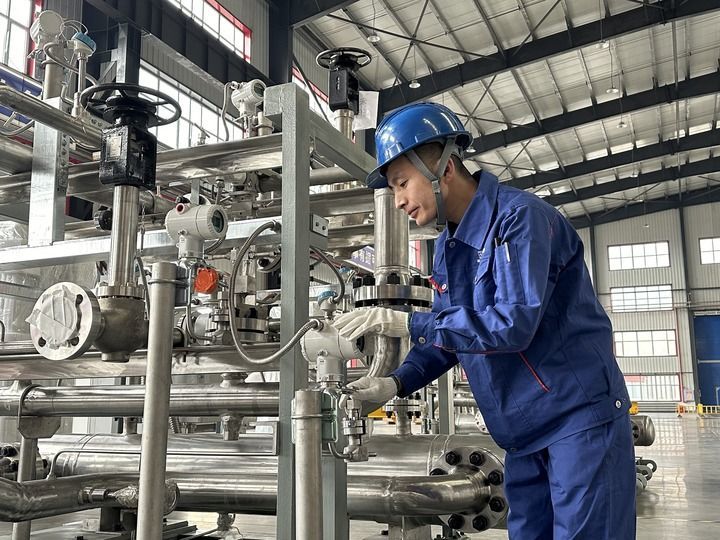 关涛正在检查氦气压缩机管路组压力表。新华社记者朱悦 摄