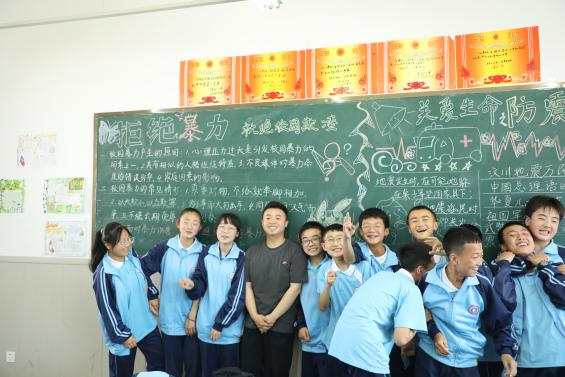 周思武(左四)支教时与孩子们在一起合影(央广网发 天津美术学院供图)