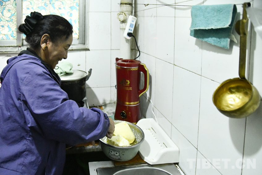 图为卓嘎将新鲜的酥油放入全自动酥油茶壶内 摄影:赵振宇