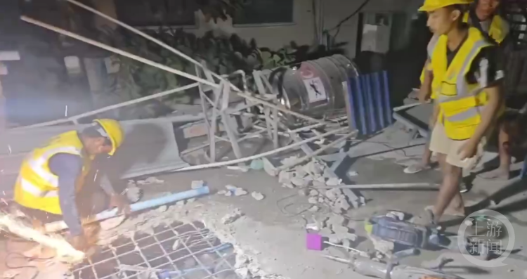 救援团队成员在垮塌建筑中切割钢筋。视频截图