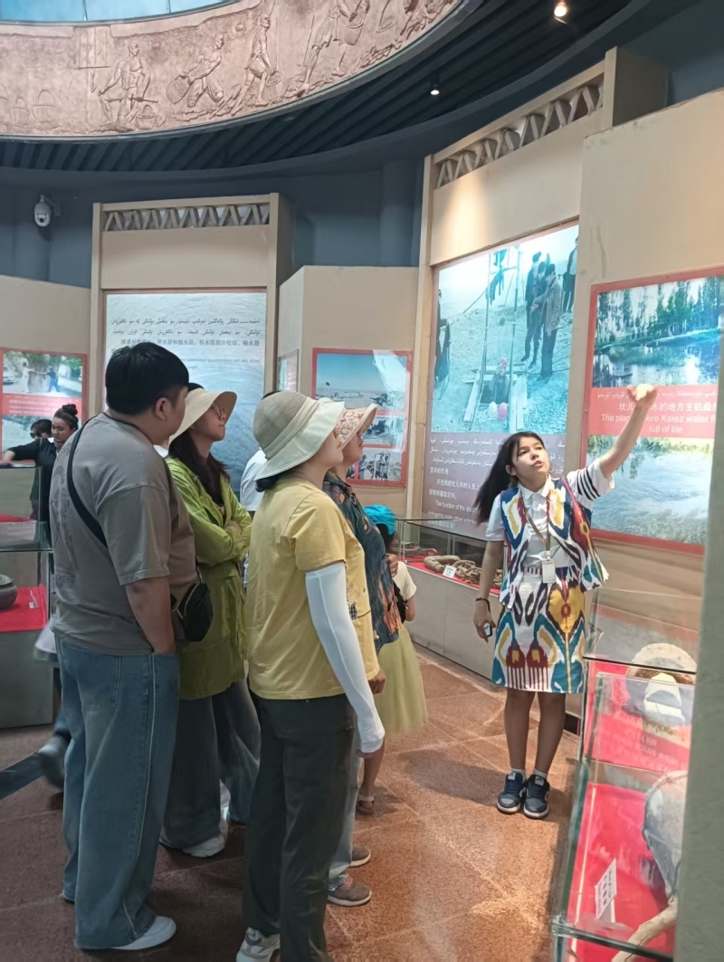 女儿努尔孜亚在给游客讲解坎儿井的故事。吐尔逊娜依&middot;胡吉艾合买提供图