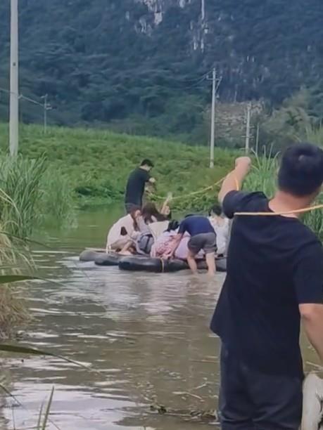 训信村部分路段因积水需坐皮筏通行（网络视频截图）
