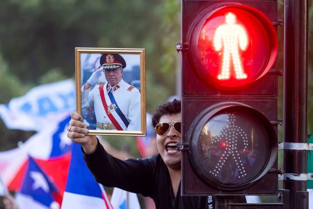 ◆卡斯特的竞选集会上,有支持者举起皮诺切特的照片。