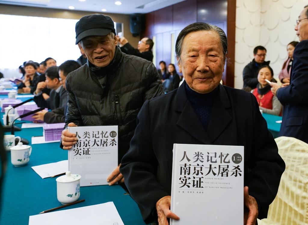 ↑2016年12月12日，在南京举行的“以史为鉴、警示未来”2016年系列图书首发式上，夏淑琴（前）展示获赠图书。