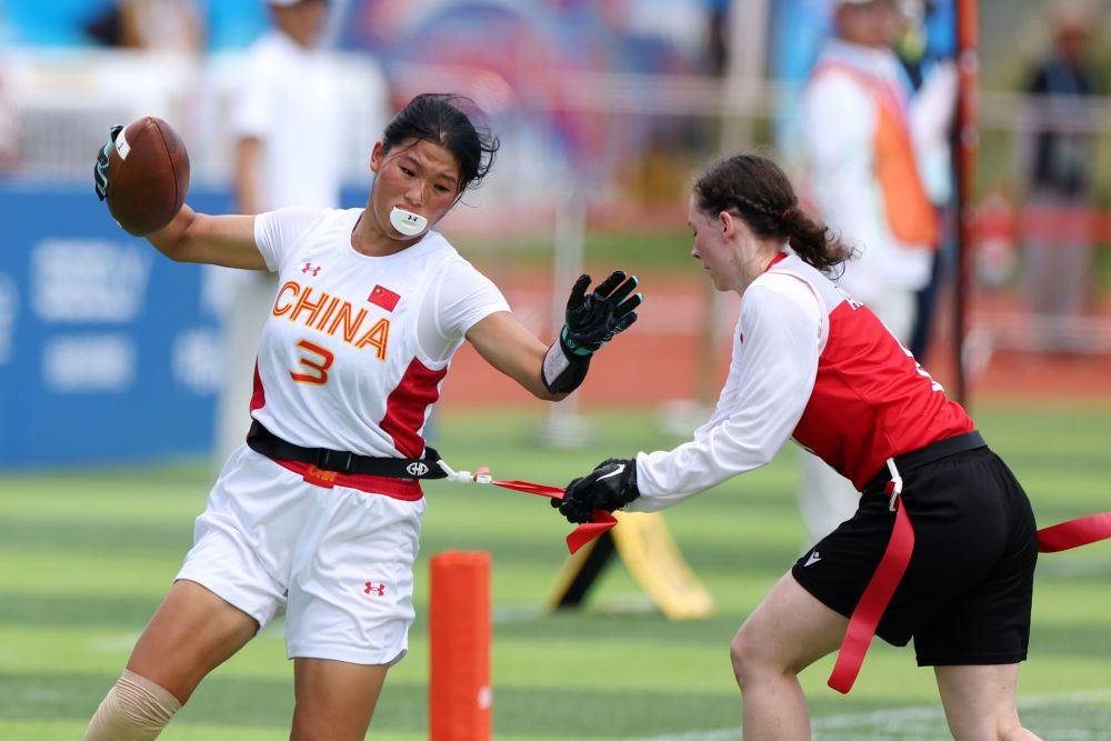 8月14日，在2025年成都世运会腰旗橄榄球女子预赛A组比赛中，中国队45:47不敌奥地利队。图为中国队球员高子旋（左）在比赛中。新华社记者 陈斌 摄