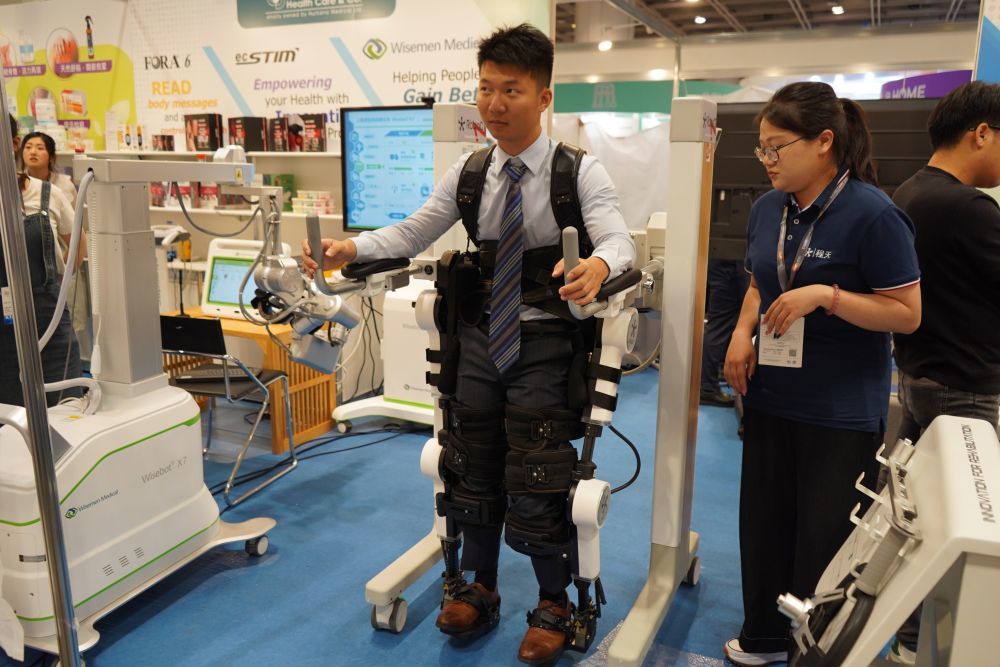 在第16届香港国际医疗及保健展上,工作人员穿戴外骨骼机器人进行操作演示(5月26日摄)。新华社发(郭辛摄)
