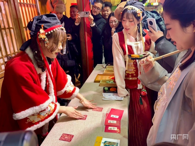 游客正在情景式演艺街区与演员互动（央广网记者 郭明彤 摄）